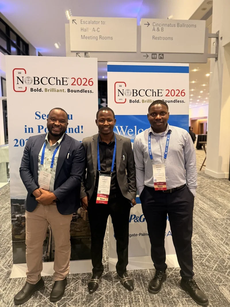 Three conference attendees beside NOBCChE 2026 banners