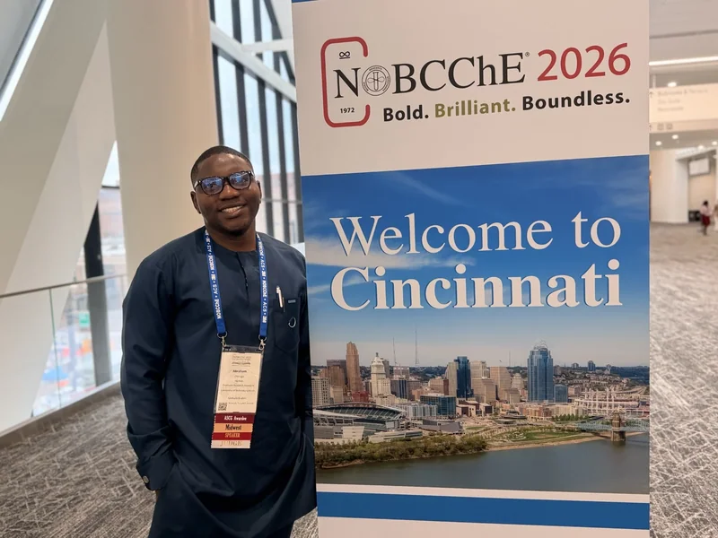 Portrait beside the NOBCChE 2026 welcome banner in Cincinnati